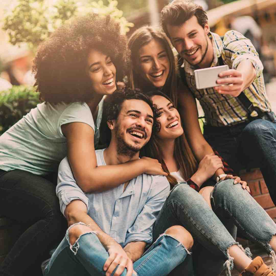 A picture of 5 friends taking a selfie together.